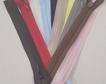 May include: Assortment of 10 zipper pulls in various colors, including black, red, white, blue, brown, pink, beige, yellow, and gray. The zippers are arranged in a fan shape.