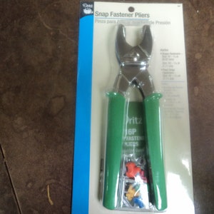 May include: Green handled snap fastener pliers with 16 snap fasteners included. The packaging says "Snap Fastener Pliers" and "Pritcz 16P Fasteners Pliers".