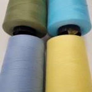 May include: Four spools of thread in different colors: green, blue, yellow, and light blue. The spools are all the same size and shape.
