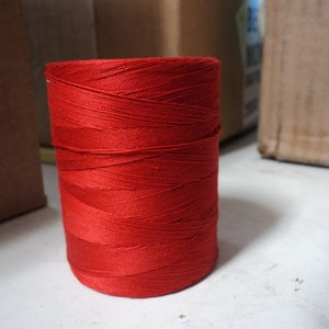 May include: A spool of bright red thread.