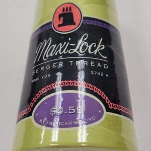 May include: A spool of Maxi-Lock serger thread in a light green color. The spool is labeled "Maxi-Lock Serger Thread" and has a price tag of $4.59. The spool is 3000 yards or 2742 meters.
