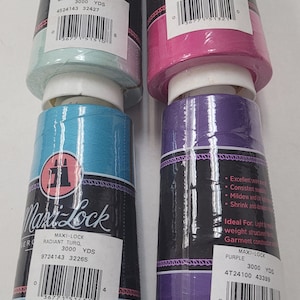 May include: Four spools of Maxi-Lock serger thread in different colors: mint green, fuchsia, turquoise, and purple. Each spool contains 3000 yards of thread and has a barcode label with the color name and yardage.