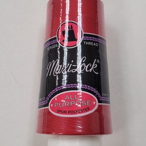 Peut inclure: Une bobine de fil polyester Maxi-Lock tout usage rouge pour surjeteuse et machine à coudre. La bobine est étiquetée avec le nom de la marque et le type de fil. Elle mesure 3000 yards (2742 mètres).