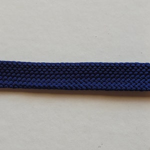 Puede incluir: Primer plano de un cordón de zapato tejido de color azul oscuro.