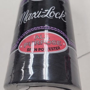 May include: A spool of black Maxi-Lock All Purpose spun polyester thread. The spool has a white label with the brand name and a red label that says "All Purpose Spun Polyester".