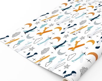 May include: White wrapping paper with a repeating pattern of yellow airplanes, blue clouds, white stars, and orange crescent moons.