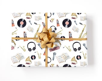 May include: A white gift box with a gold bow and a musical themed wrapping paper. The paper features a repeating pattern of saxophones, sheet music, gramophones, headphones, and vinyl records.
