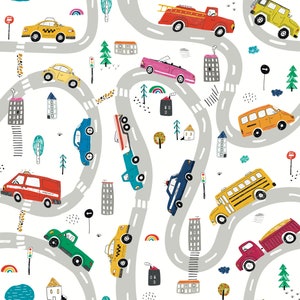May include: A colorful illustration of a city scene with winding roads, buildings, trees, and various vehicles including a yellow school bus, a red fire truck, a police car, a taxi, a delivery truck, and an ambulance.
