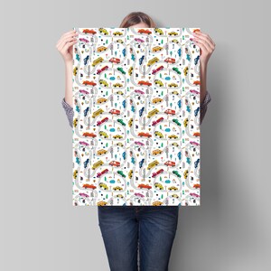 May include: A white background with a repeating pattern of colorful cars, trucks, and buses driving on winding roads. The pattern includes traffic lights, trees, and clouds.