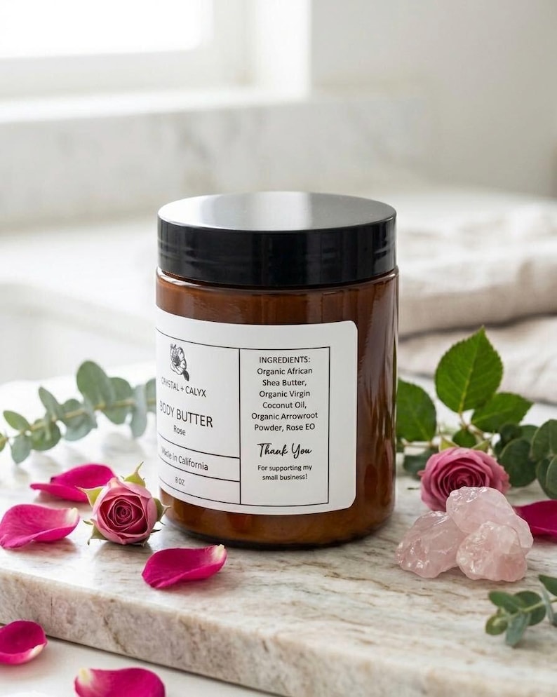 May include: An 8 oz amber plastic jar of Crystal + Calyx Rose Body Butter with a black lid. The white label lists ingredients including organic African shea butter, organic virgin coconut oil, organic arrowroot powder, and rose essential oil.