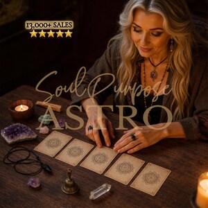 May include: Five rectangular cards with intricate circular mandala designs arranged in a row on a wooden surface. The scene includes a small brass bell, a clear quartz crystal, a purple amethyst cluster, a black pendant, and a lit candle.