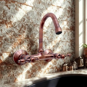 Puede incluir: Un grifo de pared de color cobre con un caño curvo y dos manijas. El grifo está montado en una pared de azulejos texturizados, marrones y beige. El diseño es vintage y decorativo.