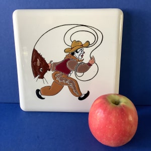 Art Deco tile Trivet of a Rodeo Cowboy Clown with a lasso and pulling a bull by its horns.