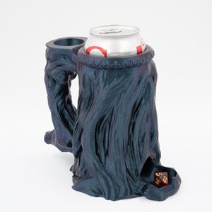 Könnte beinhalten: Ein schwarzer und blauer 3D-gedruckter Würfelturm mit einem Dosenhalter und einem roten Würfel im Inneren. Der Turm ist in Form eines Baumstamms mit einer strukturierten Oberfläche gestaltet.