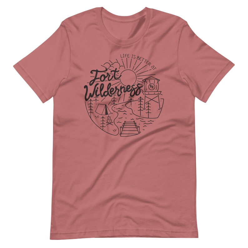 May include: A pink t-shirt with a black graphic design that says "Life is better at Fort Wilderness" with a sun, trees, a tent, a campfire, a lake, a dock, and a water tower.