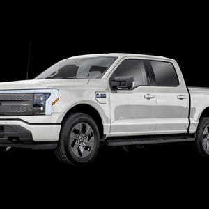 May include: A white Ford F-150 Lightning pickup truck. The truck has a modern design with a large front grille, LED headlights, and black wheels. The Lightning logo is visible on the rear. The truck is set against a black background.