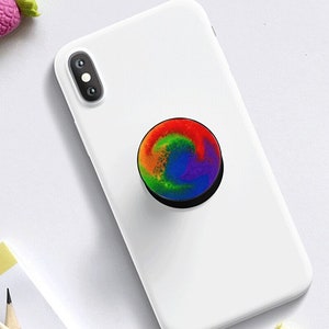 Pode incluir: Uma capa de telefone branca com um suporte de telefone em espiral arco-íris.