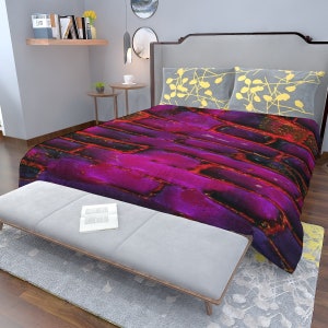 May include: A purple and red abstract patterned duvet cover with a gray headboard and two yellow patterned pillows.