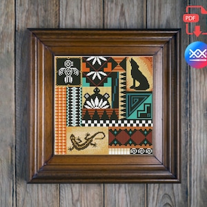 Könnte beinhalten: Ein gerahmtes Kreuzstich-Kunstwerk mit einem indianischen Design. Das Kunstwerk zeigt geometrische Muster, einen heulenden Wolf, eine Eidechse und andere symbolische Figuren in Orange-, Türkis-, Schwarz- und Weißtönen. Der Rahmen ist dunkelbraun.