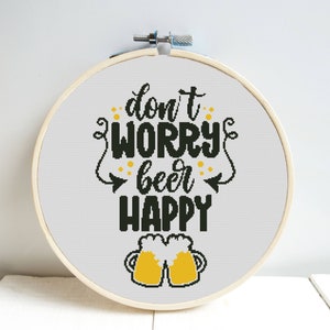 May include: A white embroidery hoop with a black and yellow design that says "Don't worry, beer happy" with two yellow beer mugs.