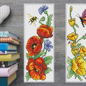 May include: Two cross-stitch bookmark designs. The first bookmark features a bee and red poppies. The second bookmark features a butterfly and yellow flowers.