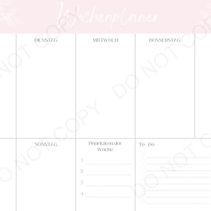 May include: A weekly planner with a pink background and a white floral design. The planner has sections for each day of the week, as well as a section for to-do items and priorities.
