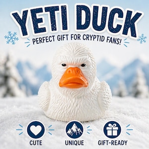 May include: A white rubber duck with a textured body and an orange beak. The text "YETI DUCK" is displayed above the duck, with the phrase "PERFECT GIFT FOR CRYPTID FANS!" below. The words "CUTE", "UNIQUE", and "GIFT-READY" are also displayed.