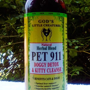 May include: A 4-ounce bottle of God's Little Creatures Pet 911 Doggy Detox & Kitty Cleanse natural herbal blend. The bottle is yellow with green accents and features a dog and cat paw print logo. The label lists benefits for cats and dogs, including optimal liver support, superior natural cleanse, supports healthy appetite, maintains healthy weight, immune system support, and natural and chemical free.