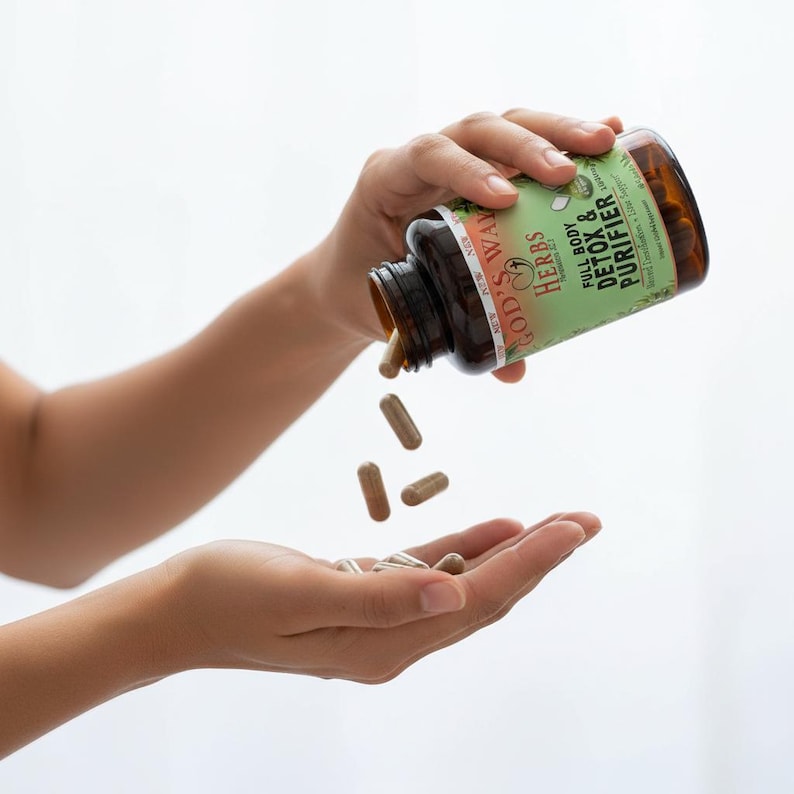 Perosn pouring Full Body detox Herbal Supplement capsules into their hand.