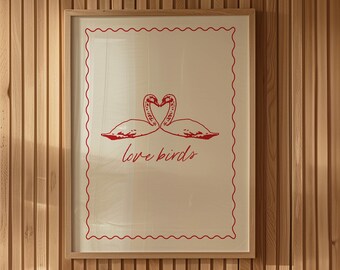 Può includere: Una stampa incorniciata con un bordo rosso e uno sfondo bianco. La stampa presenta un'illustrazione rossa di due uccelli che si guardano, con le loro teste che formano un cuore. Il testo "love birds" è scritto in rosso sotto gli uccelli.
