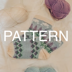 May include: A pair of knitted socks with a geometric pattern in shades of blue, green, and purple. The socks are lying on a white surface with three balls of yarn in different colors: white, light blue, and purple.