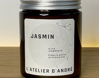 May include: A brown glass candle jar with a silver lid. The label reads "JASMINE" and "Cire végétale Fabrication artisanale L'ATELIER D'ANDRÉ".
