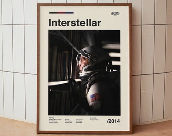 May include: A movie poster for the film "Interstellar" featuring a close-up of an astronaut in a spacesuit looking out of a window. The poster is framed in wood and has the title "Interstellar" and the year "2014" printed on it.