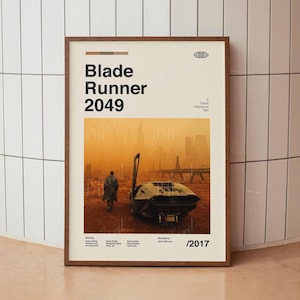 Könnte beinhalten: Ein Filmplakat für den Film Blade Runner 2049, das eine futuristische Stadtlandschaft im Hintergrund und eine einsame Figur zeigt, die auf ein futuristisches Fahrzeug im Vordergrund zugeht. Das Plakat ist in einem braunen Rahmen und trägt den Titel "Blade Runner 2049" in großen, fetten Buchstaben oben. Der Regisseur, Denis Villeneuve, wird unten auf dem Plakat genannt.
