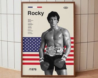 Könnte beinhalten: Ein Vintage-Filmplakat für den Film "Rocky" mit Sylvester Stallone in Schwarzweiß. Das Plakat hat einen rot-weiß-blauen amerikanischen Flaggenhintergrund und den Text "Rocky / 1976".