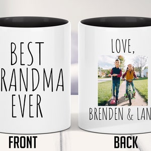 May include: White ceramic coffee mug with a black handle and black rim. The front of the mug says "Best Grandma Ever". The back of the mug has a photo of two children on bikes and says "Love, Brenden & Lana".