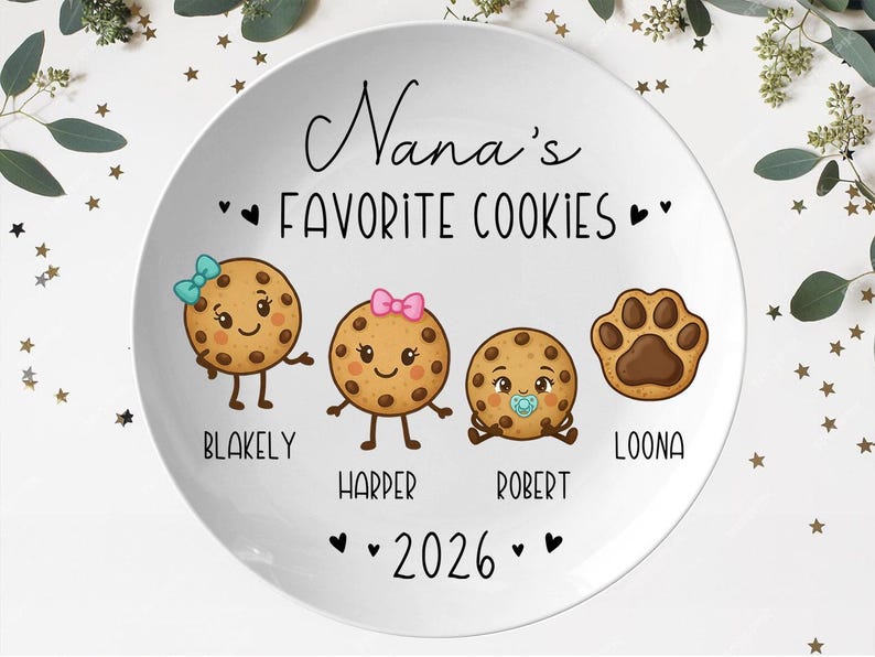 Peut inclure: Une assiette en c&eacute;ramique blanche avec le texte "Nana's Favorite Cookies" en &eacute;criture noire. L'assiette pr&eacute;sente des biscuits de dessin anim&eacute; avec des visages et des noms : Blakely, Harper, Robert et Loona. L'ann&eacute;e "2026" est &eacute;galement affich&eacute;e.