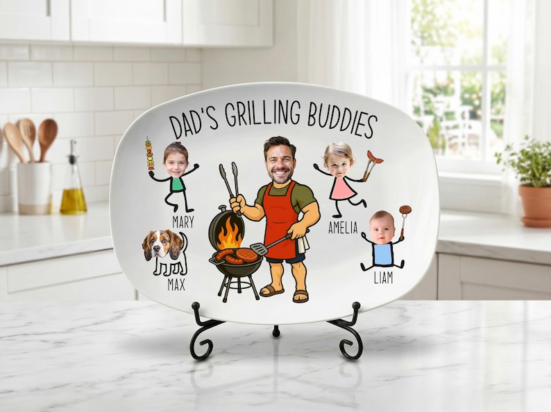 Peut inclure: Un plat ovale blanc avec le texte "DAD'S GRILLING BUDDIES" et des illustrations de dessins anim&eacute;s d'un homme grillant, de trois enfants et d'un chien. L'homme porte un tablier et tient des ustensiles de cuisine. Le plat est sur un support en m&eacute;tal noir.