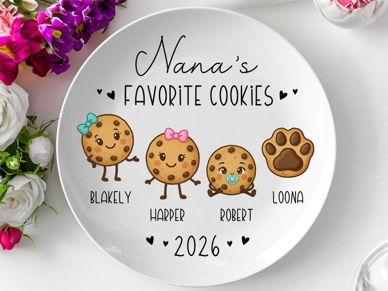 Peut inclure: Assiette en c&eacute;ramique blanche avec le texte "Nana's Favorite Cookies" et l'ann&eacute;e 2026. L'assiette pr&eacute;sente quatre illustrations de biscuits de dessin anim&eacute;, chacune avec un nom : Blakely, Harper, Robert et Loona. Les biscuits ont des visages et des accessoires mignons.
