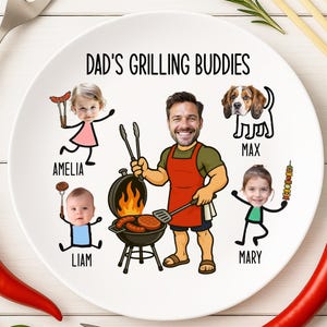 Peut inclure: Une assiette en c&eacute;ramique blanche avec le texte "DAD'S GRILLING BUDDIES" et des illustrations de dessins anim&eacute;s d'un homme, de trois enfants et d'un chien. L'homme fait griller de la nourriture sur un barbecue. Les enfants et le chien sont nomm&eacute;s.