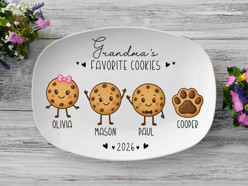 Peut inclure: Plat ovale blanc avec l'inscription "Grandma's Favorite Cookies". Repr&eacute;sente des biscuits de dessin anim&eacute; avec les noms Olivia, Mason, Paul et Cooper. Comprend une empreinte de patte et l'ann&eacute;e 2026.
