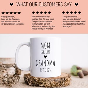 May include: White ceramic mug with black text that reads "MOM EST. 1998" and "GRANDMA EST. 2025". A small black heart is between the two lines of text.