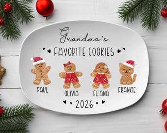 May include: An oval white ceramic plate featuring the black text Grandma's FAVORITE COOKIES and 2026. The design includes four gingerbread-style figures labeled Paul, Olivia, Eliana, and Frankie, decorated with red hats and clothing.