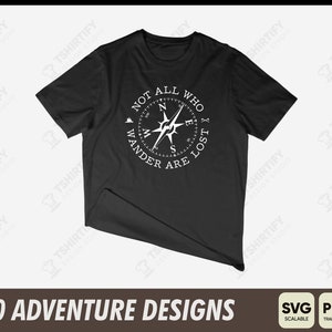 Pode incluir: Camiseta preta com um design de b&uacute;ssola branco e o texto "Not all who wander are lost".