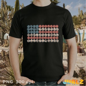 May include: A black t-shirt with a floral design that resembles the American flag. The flowers are red, white, and blue.