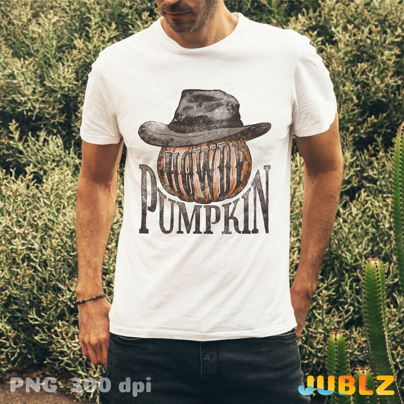May include: A white t-shirt with a graphic of a pumpkin wearing a cowboy hat. The text "Howdy Pumpkin" is printed below the pumpkin.