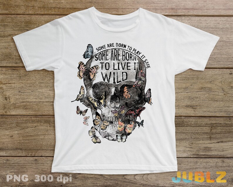 May include: White t-shirt with a black and white skull graphic with butterflies and the text "Some are born to play it safe. Some are born to live it wild."