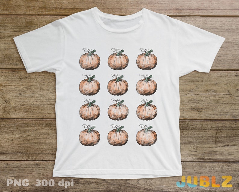 Puede incluir: Camiseta blanca con un patr&oacute;n repetido de calabazas naranjas con tallos verdes. Las calabazas est&aacute;n dibujadas en estilo acuarela.