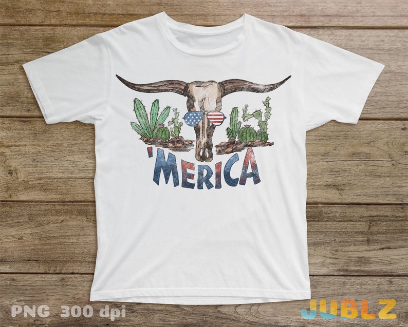 May include: White t-shirt with a distressed graphic of a bull skull wearing sunglasses and a red, white, and blue bandana. The skull is surrounded by cacti and the text 'Merica' is printed below.