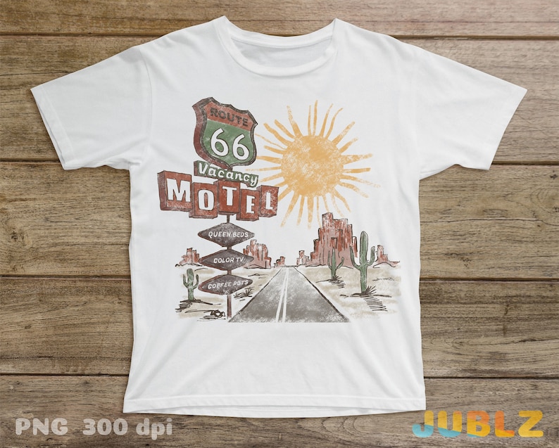 May include: White t-shirt with a vintage-style illustration of a Route 66 motel sign with a yellow sun and cacti in the background. The sign reads "Route 66 Vacancy Motel" with additional signs below that say "Queen Beds", "Color TV", and "Coffee Pots".